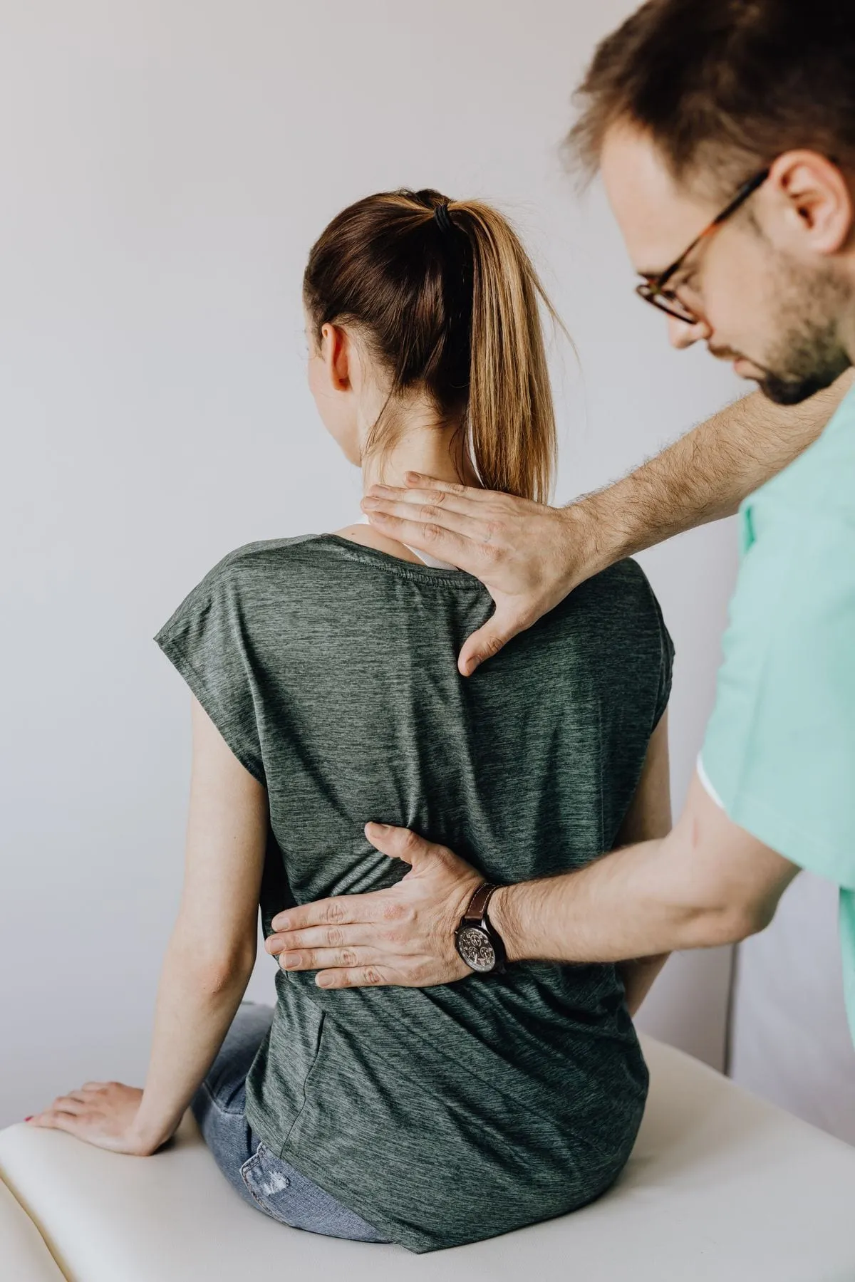 Male massage therapist working on a client's shoulders